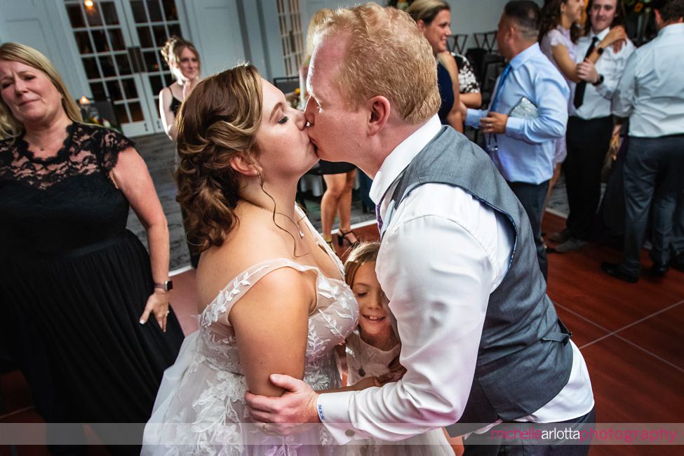 Park Avenue Club NJ wedding reception bride and groom kissing with daughter right between them