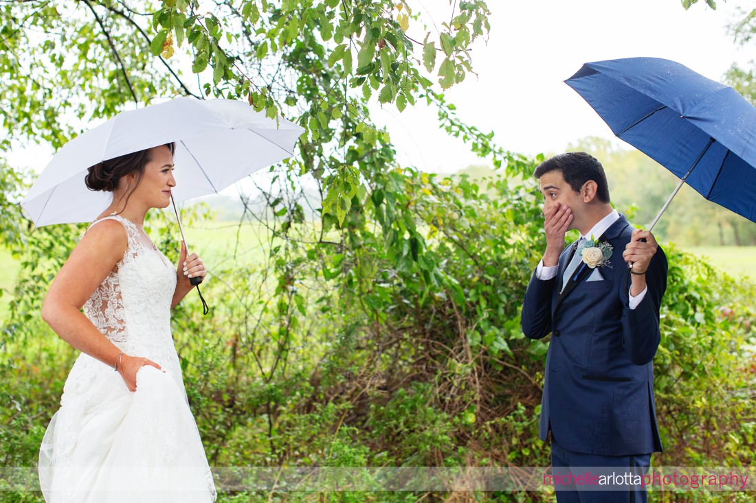 Phoenixville Pa wedding bride and groom first look in the rain with umbrellas