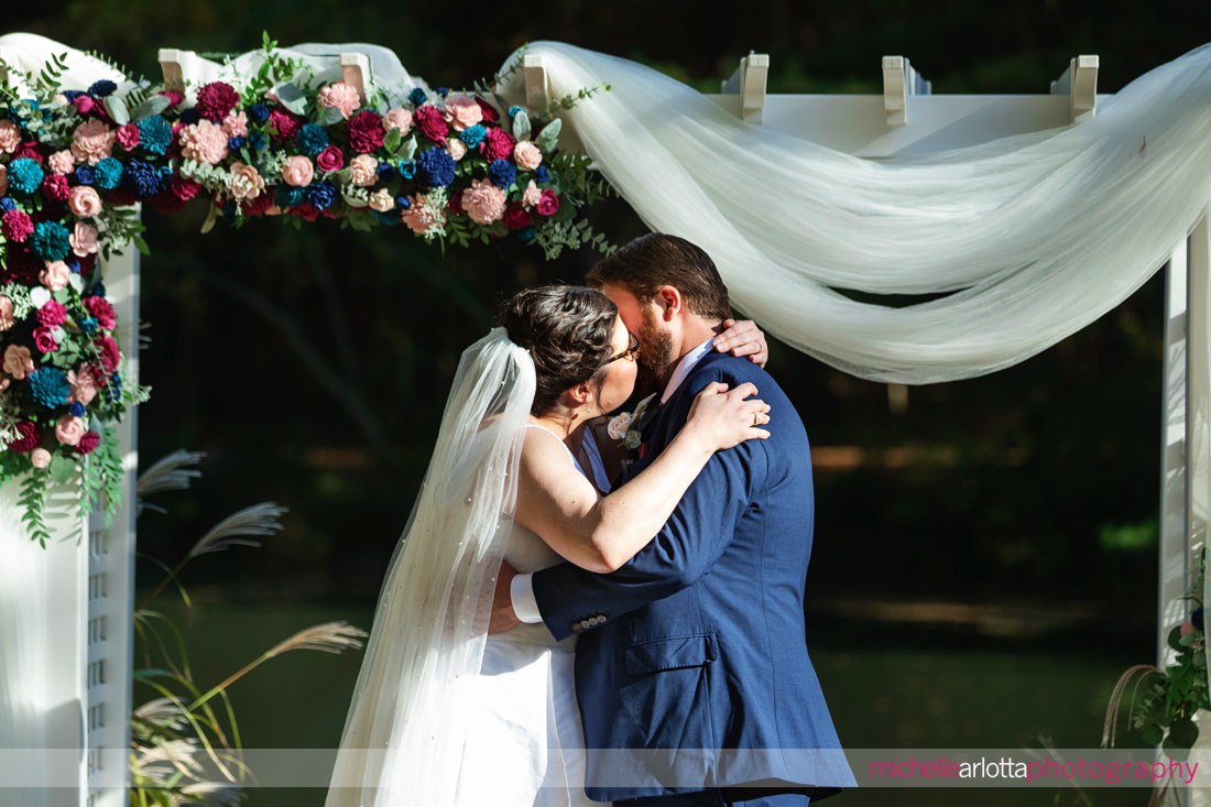 Pat's 30 acres wedding wall NJ outdoor wedding ceremony bride and groom kissing at altar by a pond