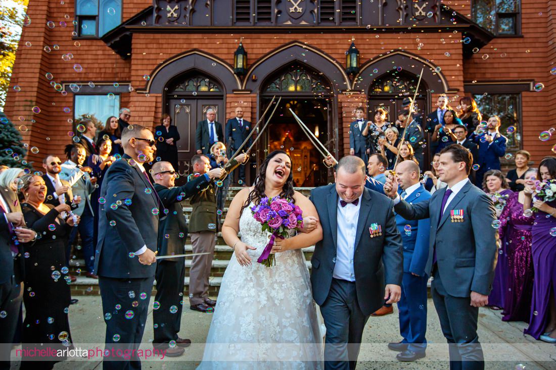 St Peter's Roman Catholic Church point pleasant beach nj wedding ceremony bride and groom exit the church with military swords and bubbles