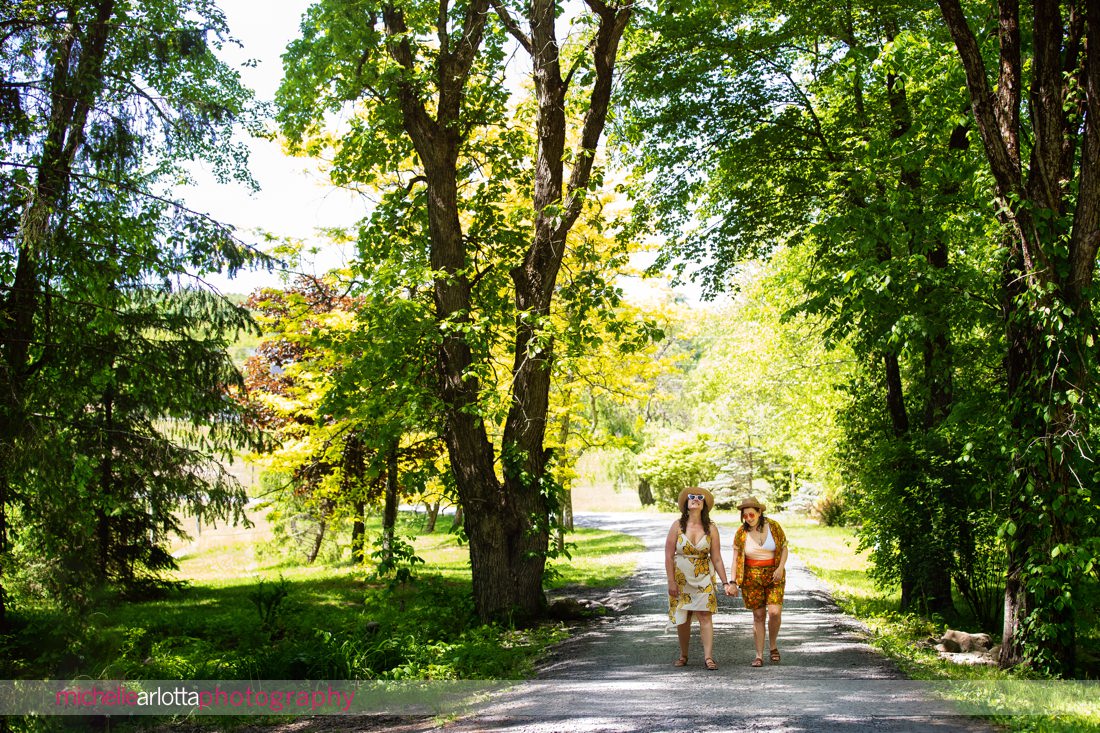 two brides-to-be walk down the road at Grateful Woods Hudson Valley NY Engagement Session