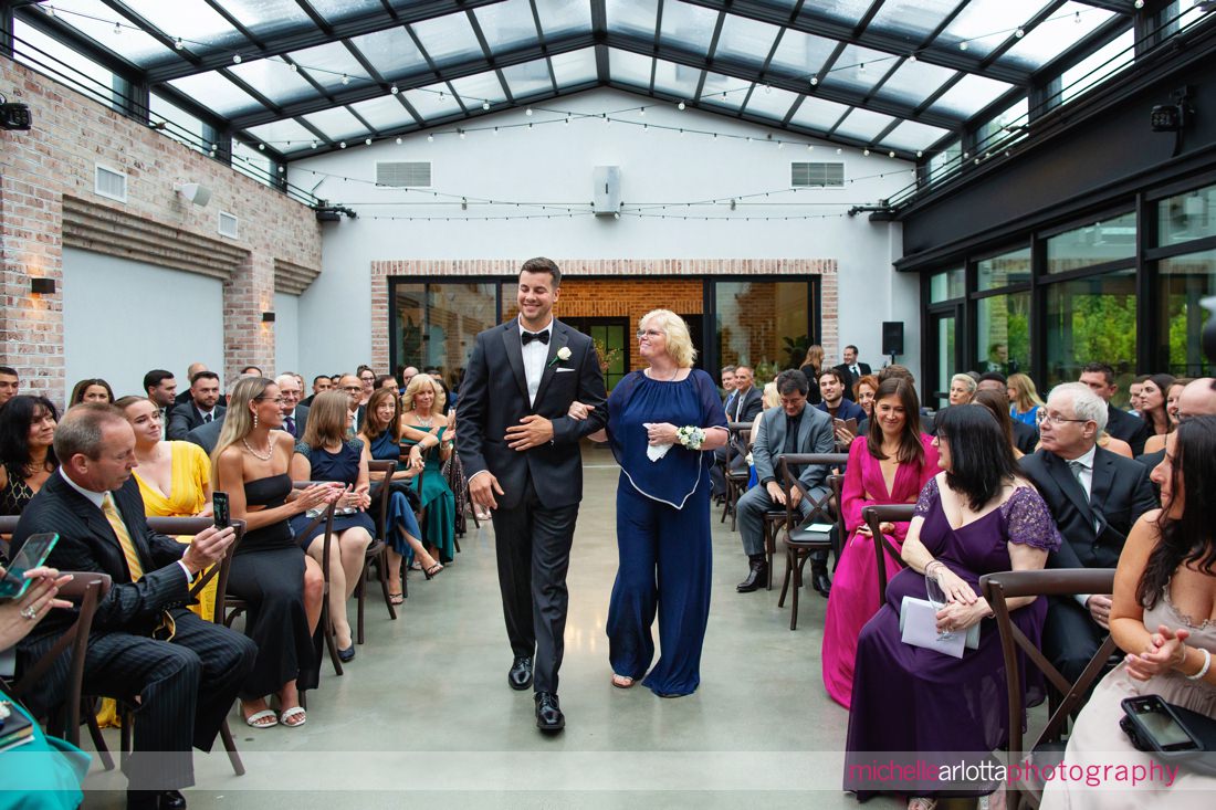Perona Farms Refinery Summer NJ wedding ceremony mother of groom looks at groom as they walk down the aisle