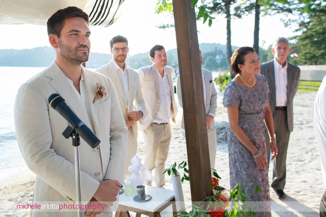 groom watches bride walk down the aisle NJ Lake Mohawk Country Club lakeside wedding ceremony