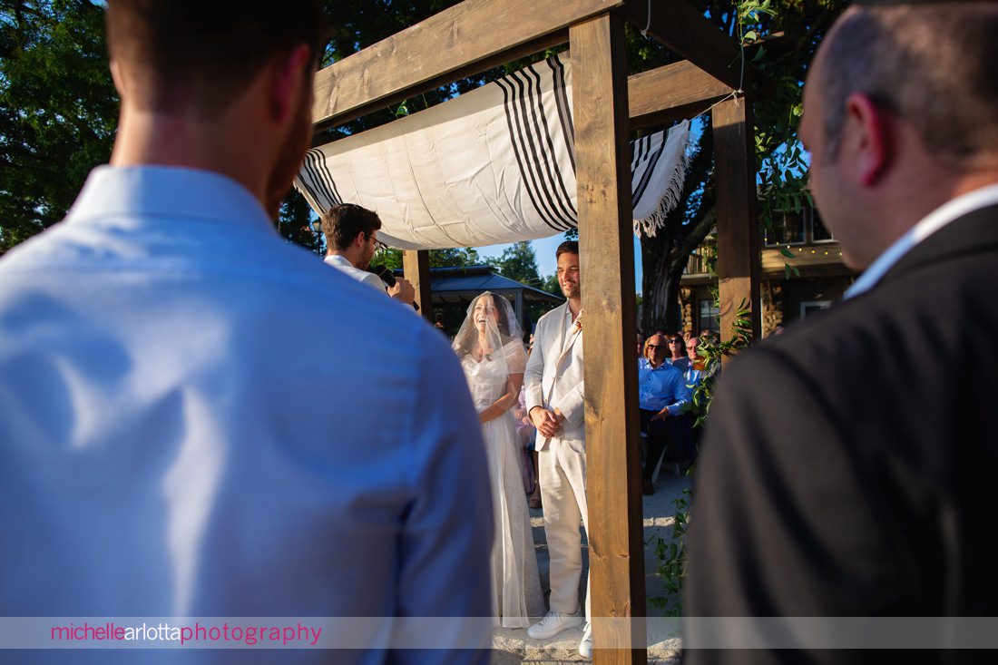 bride and groom under chuppah jewish NJ Lake Mohawk Country Club lakeside wedding ceremony