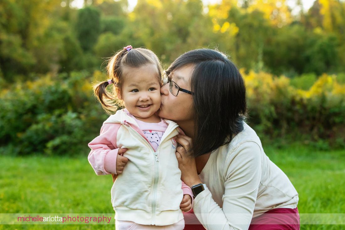 Hunterdon County NJ Mini Family Session mom gives daughter a kiss on the cheek as she smiles