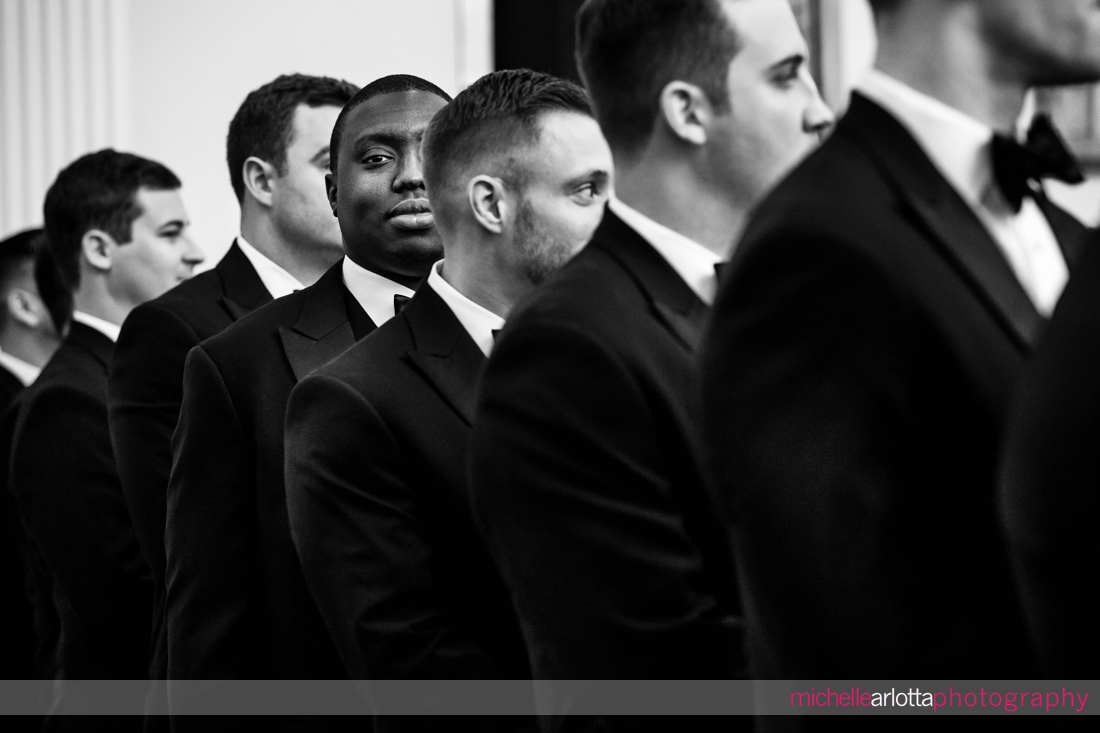 one groomsmen looking at camera during wedding ceremony while all others look forward Ryland inn coach house nj 