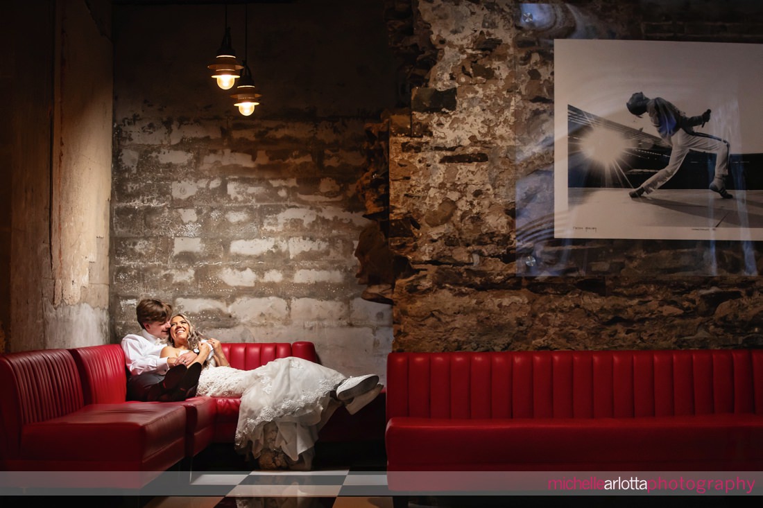 bride and groom embracing a red couch in the Logan inn at new hope pa wedding