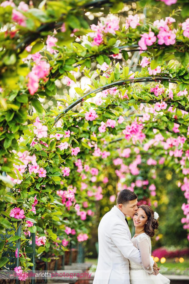 bride and groom in flower arch in nj