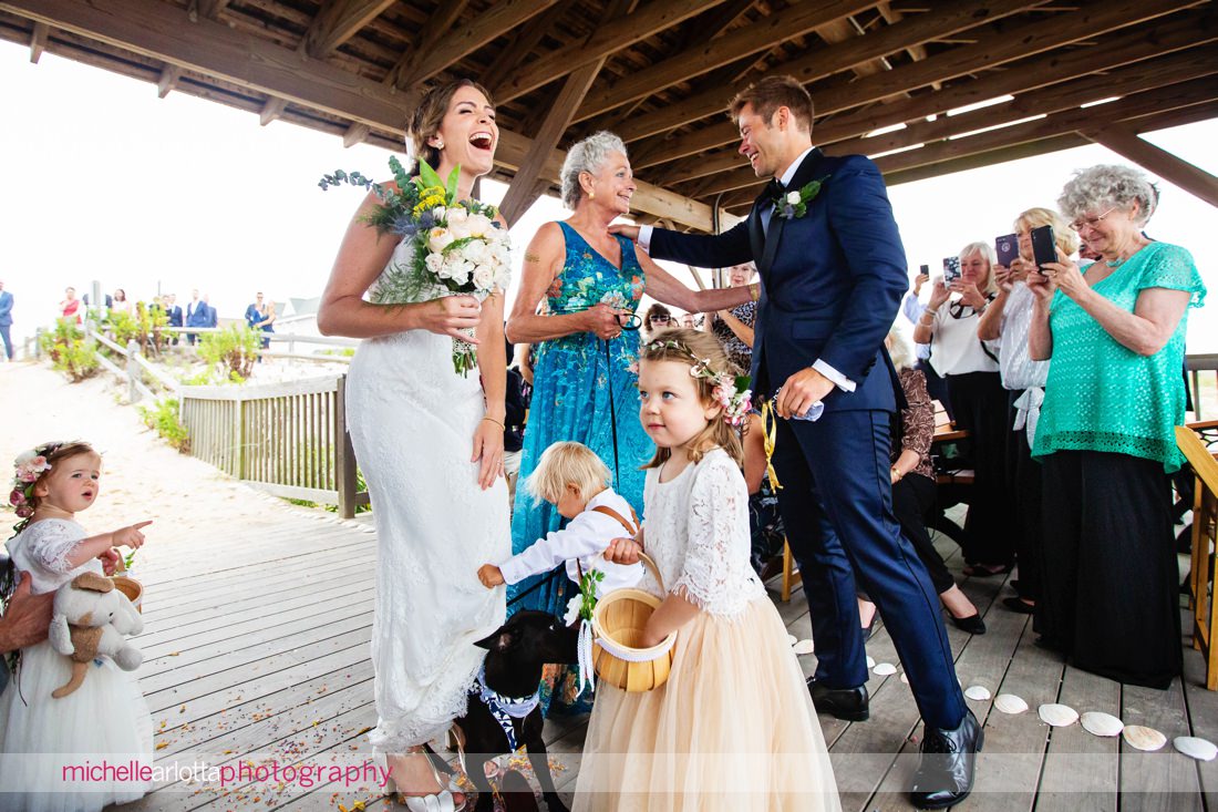 dog jumps up on bride at altar with little kids at brant beach lbi nj wedding ceremony