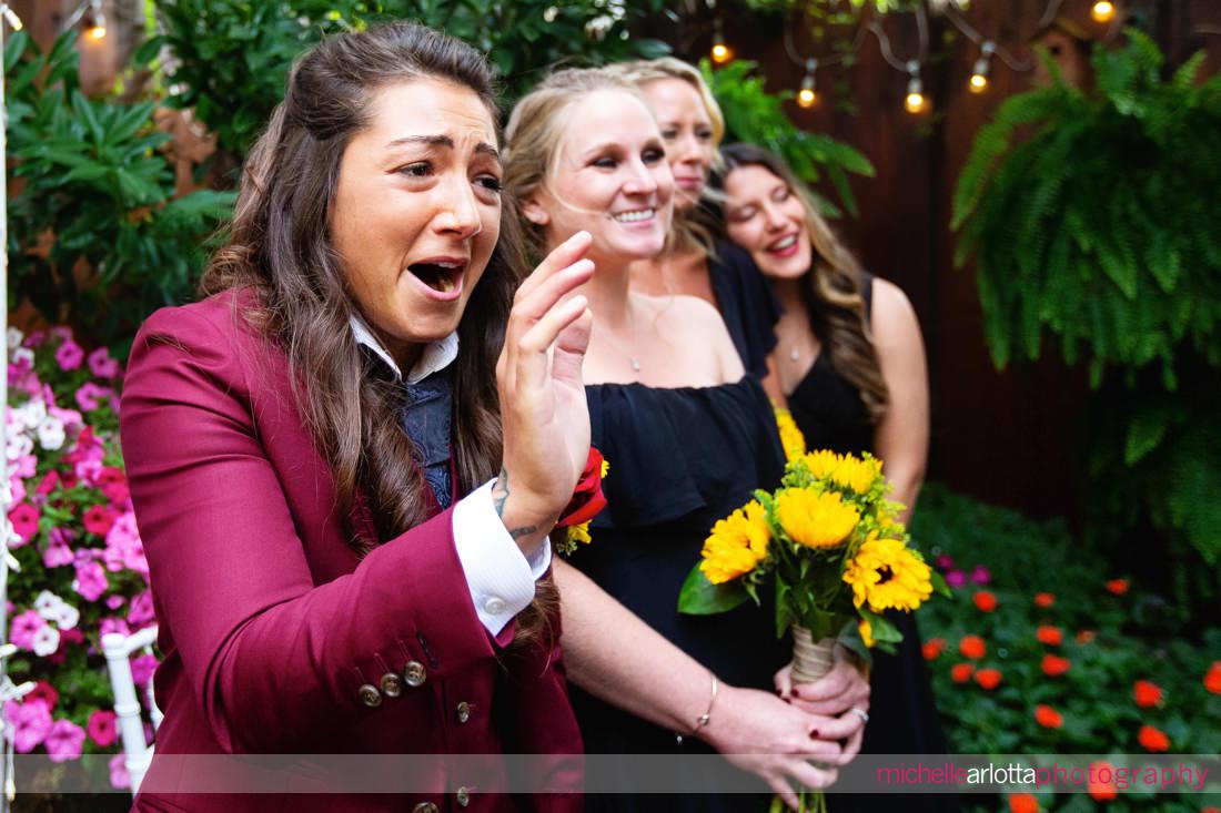 bride in maroon suit reacts as other bride walks down the aisle at the Gables LBI nj wedding ceremony