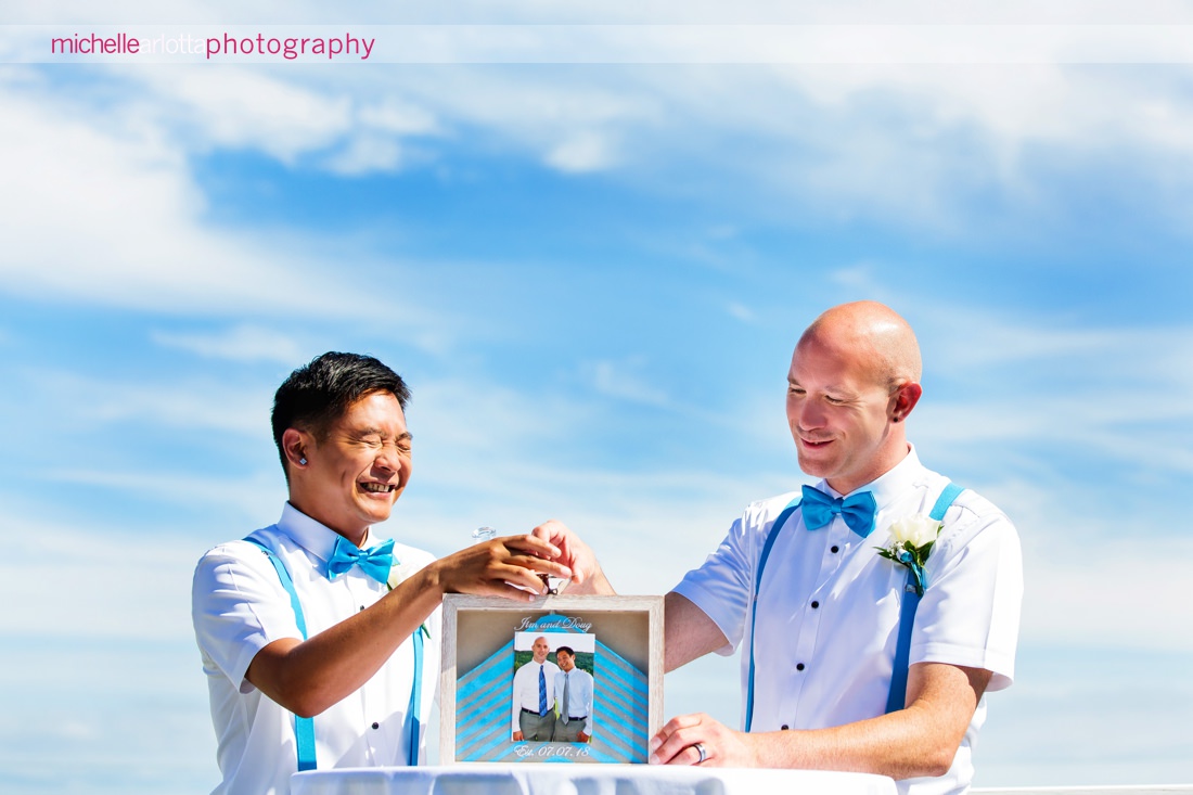 two grooms with blue bow ties pour sand during cape may nj wedding ceremony