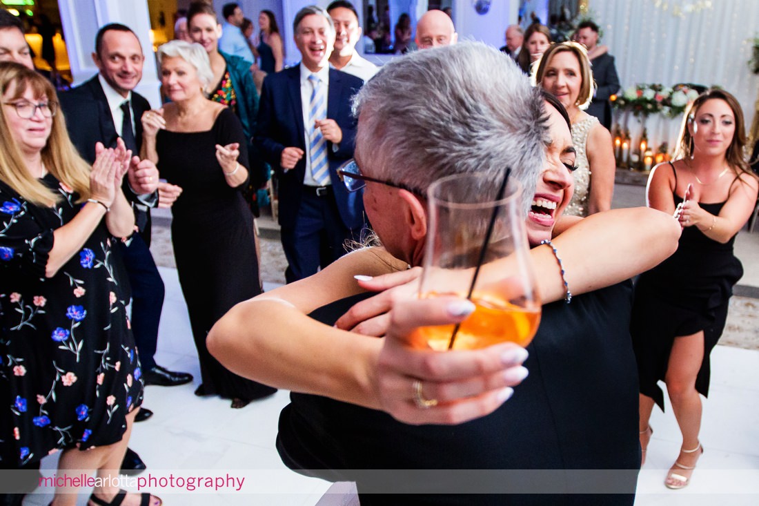 bride hugs a wedding guest with a drink in her hand at Edgewood country club nj wedding