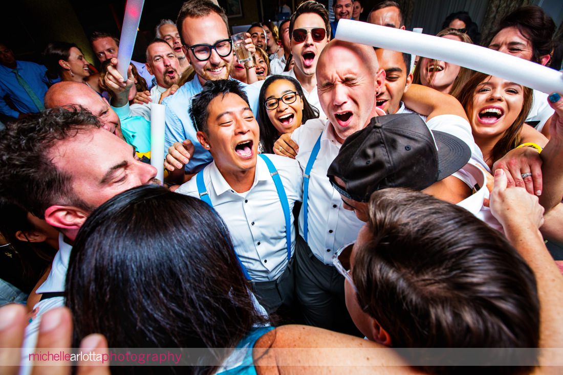 grooms with blue suspenders surrounded by friends on the dancefloor at cape may grand hotel wedding