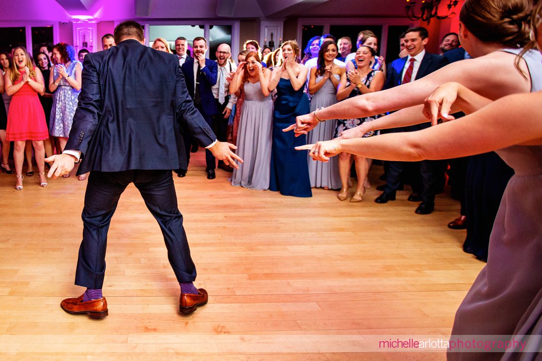 wedding guests pointing and in shock and awe of another guests moves on the dance floor at rock island lake club nj