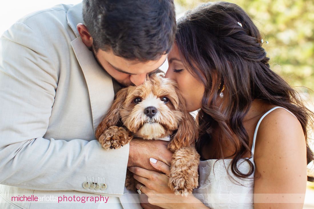bring all the dogs nj Lake Mohawk country club wedding  bride and groom kiss dog on his head at the same time
