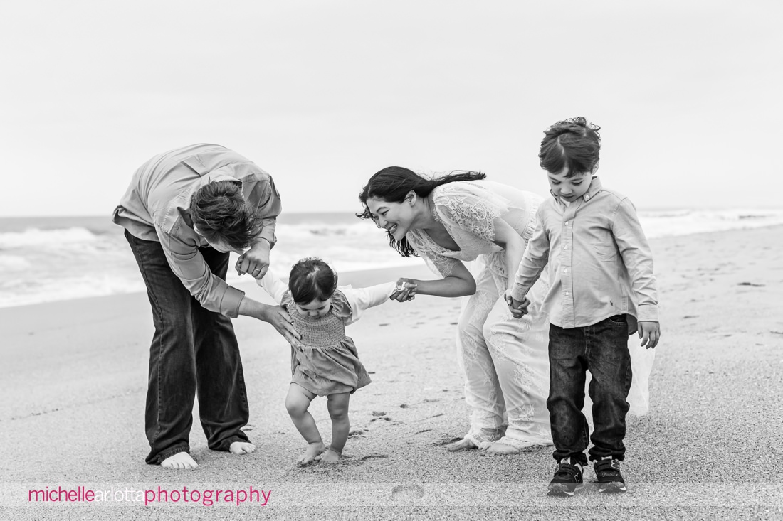 mother, father, son, daughter walk on beach during Asbury Park Beach New Jersey family portrait session