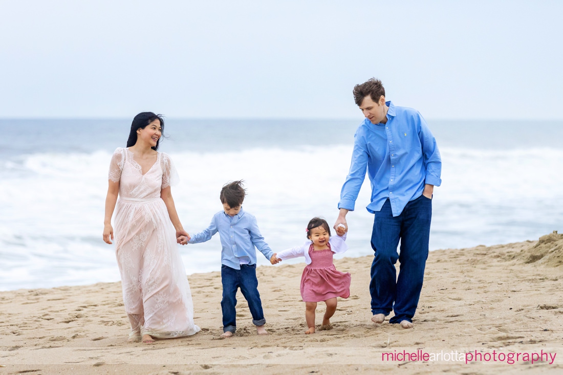 mother, father, son, daughter walk on beach during Asbury Park Beach NJ family portrait session