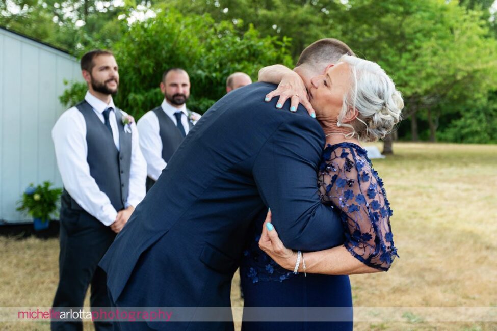 South Jersey Hammonton Backyard wedding ceremony mother of the groom hugs groom at altar