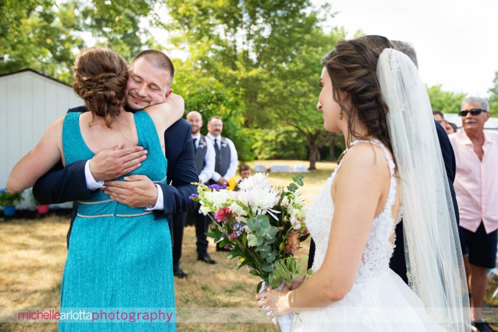 South Jersey Hammonton Summer Backyard wedding ceremony groom hugs mother of the bride at altar