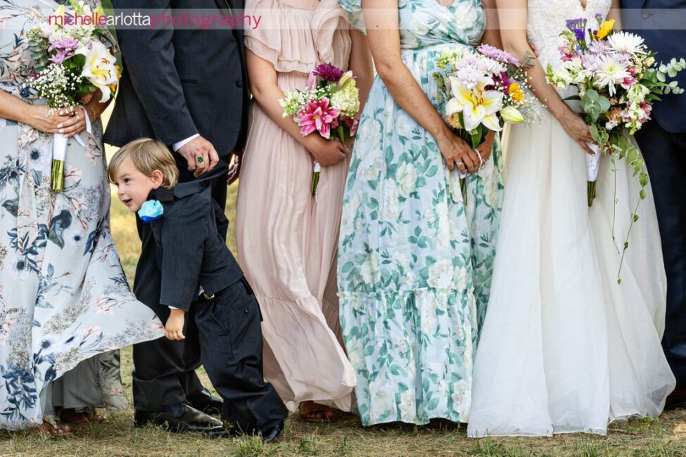 South Jersey Hammonton Summer Backyard wedding reception dancing ring bearer being pulled by the back of the jacket by dad during portraits as he struggles to stand still