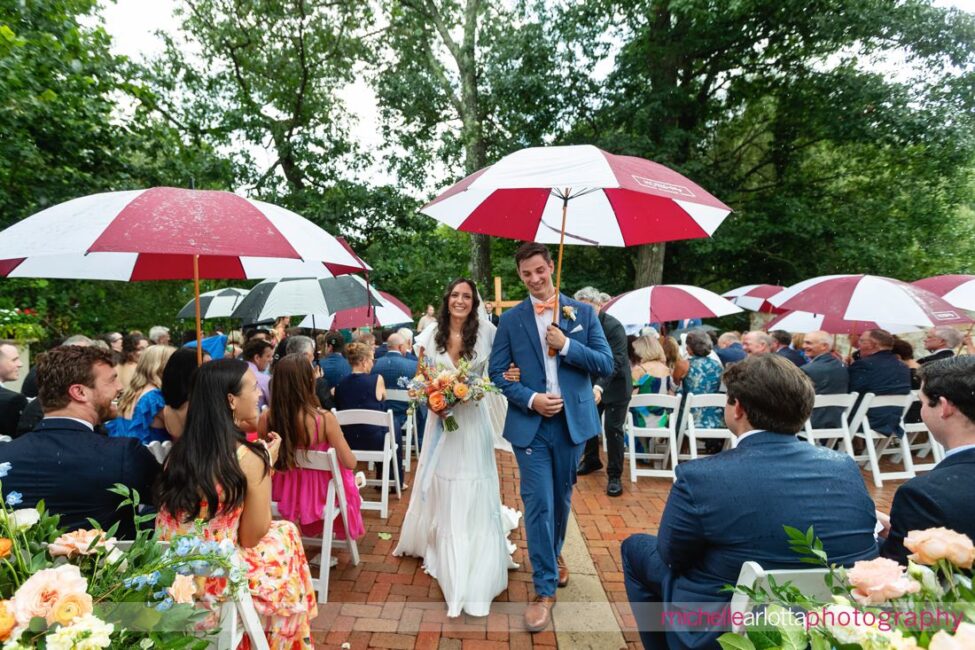 Landmark Venues Hotel Du Village New Hope PA outdoor wedding ceremony bride and groom walking down the aisle with umbrella