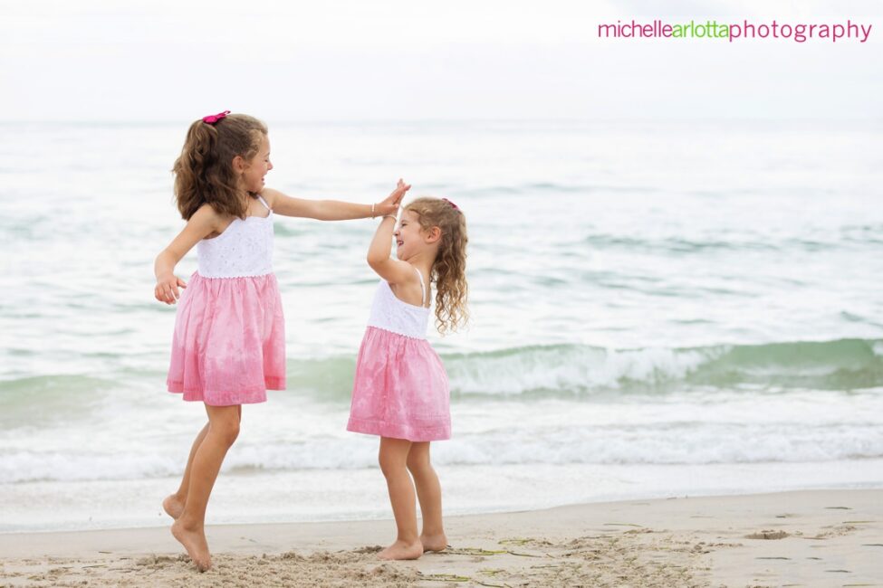 beach haven lbi nj family portrait sisters give each other a high five by the water