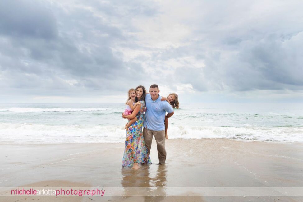 beach haven lbi nj family portrait session mom dad and two little girls cloudy and reflection on the sand