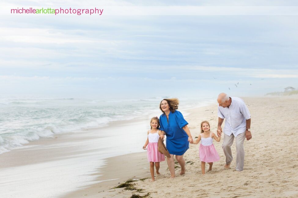 beach haven lbi nj family portrait session grandparents with two granddaughters walking on beach