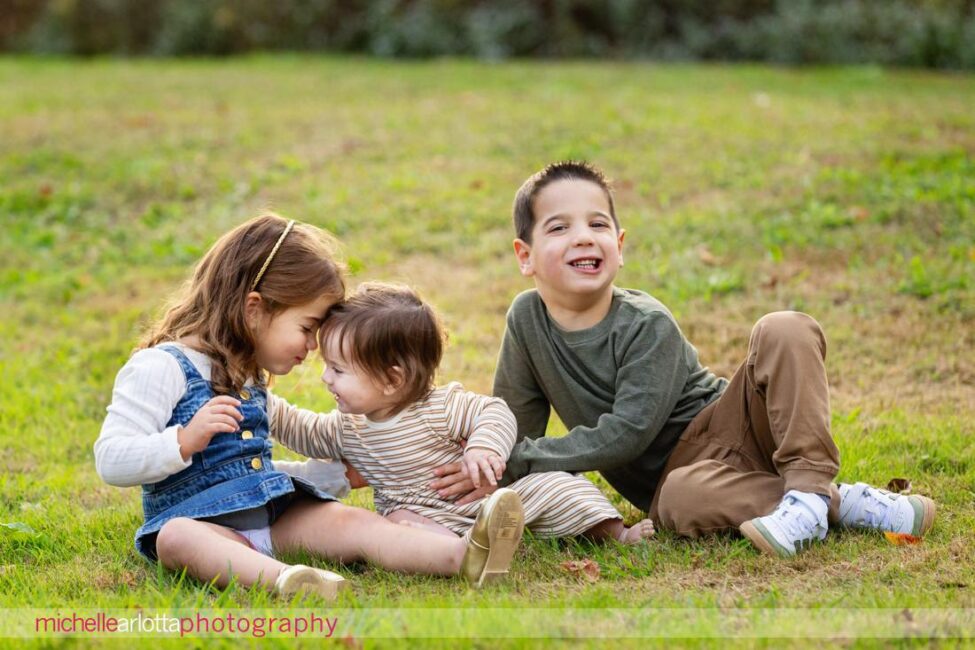 big brother and little sisters in NJ family photos at Oak Ridge Park in Clark, NJ