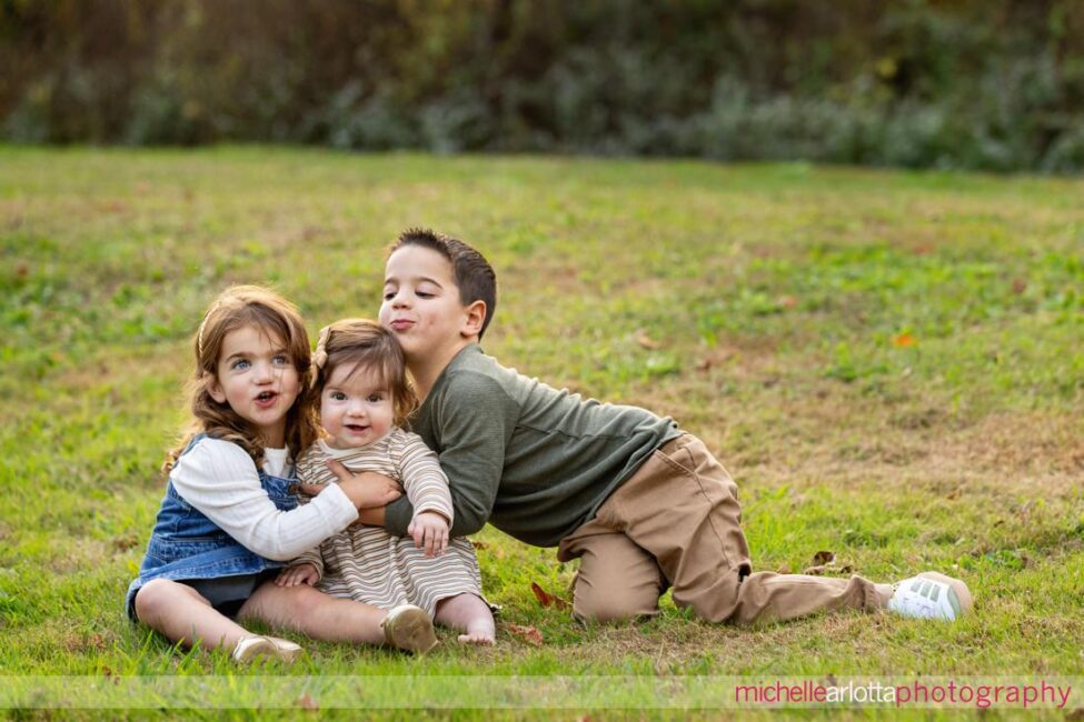 big brother and little sisters in NJ family photos at Oak Ridge Park in Clark, NJ