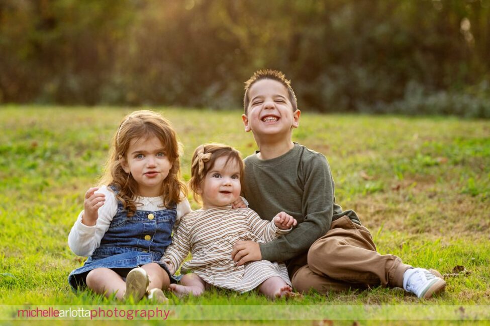 big brother and little sisters in NJ family photos at Oak Ridge Park in Clark, NJ