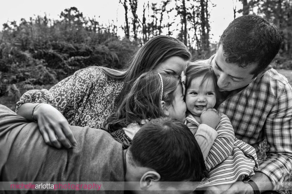 black and white family photo of family loving on baby of the family in New Jersey