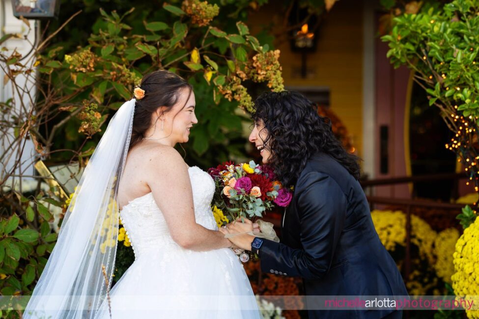 bride in suit reacts to first look with bride in white wedding gown during Gables LBI late fall wedding