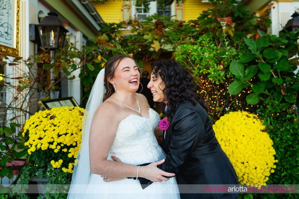 two brides laughing in relief and joy after first look in front of The Gables LBI in Beach Haven, NJ