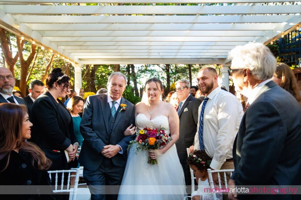 bride walks down the aisle with father during outdoor garden ceremony late fall LBI NJ gables inn wedding