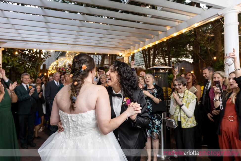 late fall outdoor garden wedding reception two brides share first dance at Gables Inn LBI NJ wedding