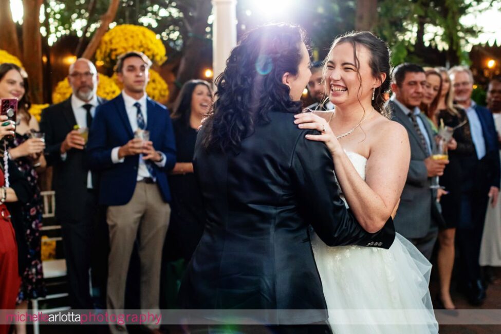 late fall outdoor garden wedding reception two brides share first dance at Gables Inn LBI NJ wedding