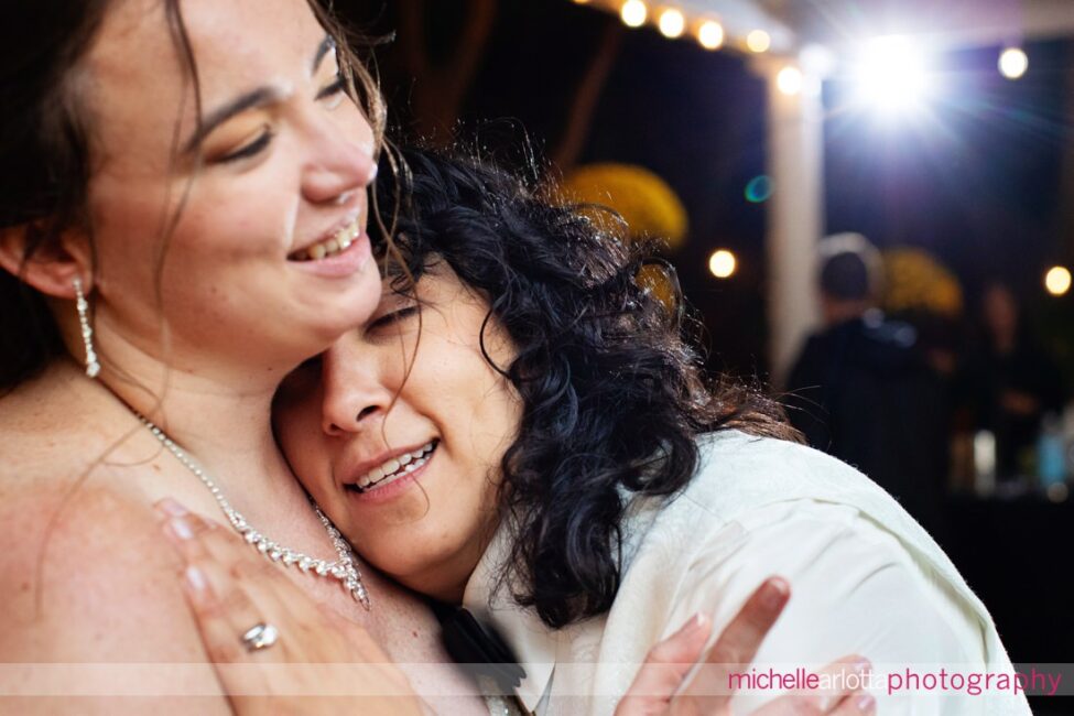 two brides embrace as one is very tired at end of at late fall Gables LBI NJ wedding reception