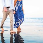 couple walks hand in hand beach haven lbi beach for engagement photos