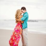 couple embraces on beach for engagement photos