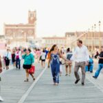 couple walking along asbury park boardwalk during nj engagement session