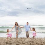 family walking hand in hand on LBI NJ beach with seagulls