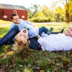 two dads play with son on the ground near their farm in nj family session