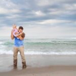 LBI beach with father holding daughter up playfully