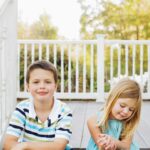 brother and sister sit on steps together during lifestyle family photo session