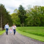 two dads walk holding hands with son down long driveway in new jersey for lifestyle family photography