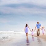 family walks hand in hand during long beach island nj family candid photos