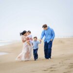 family walks hand in hand during long beach island nj family candid photos