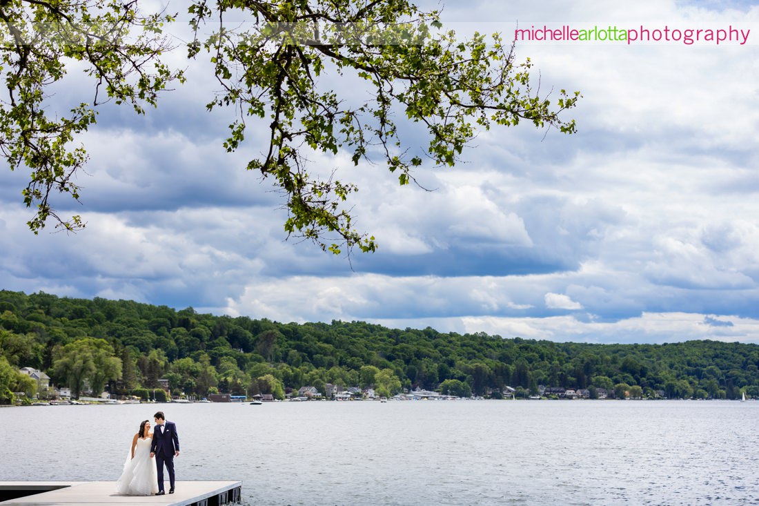 Lake Mohawk Country Club Spring Lakeside NJ wedding with bride and groom on dock with clouds
