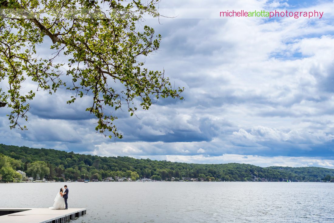 Lake Mohawk Country Club Spring Lakeside NJ wedding with bride and groom on dock with clouds